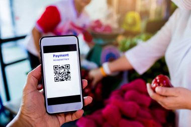 Bulanık personelle QR kod ödemesinin taranması ve pazarda meyve satın alan müşterilerin para almadan dijital ödeme yapmaları kabul edildi. Cüzdan ve nakitsiz teknoloji konsepti.