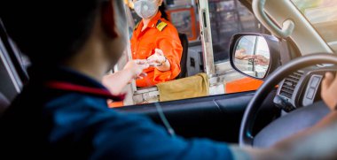 Otobanın parasını sürücüye odaklı olarak öde. Adam otoyol gişesi girişi için kasiyere para ödüyor. Yol boyunca el ödemesi ekspres geçiş ücreti. Hızlı ödeme yolu.