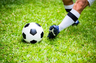 Futbolcu topu yeşil çimlerin üzerinde vurarak gol atıyor. Maç için futbolcu eğitimi. Futbol akademisinde futbolcu..