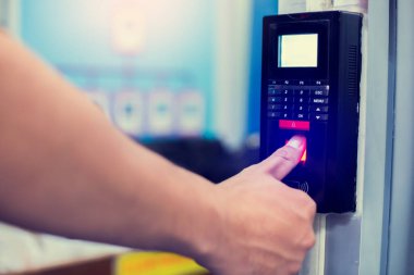 Personel, kontrol odasının ya da veri merkezinin kapısına ulaşmak için parmak taramasıyla elektronik kontrol makinesine basıyor. Veri güvenliği veya veri erişim denetimi kavramı.