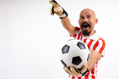 Stüdyodaki beyaz arka planda izole edilmiş kalecinin elindeki futbol topu. Futbolcu eğitimi ya da futbol maçı. Sakallı kel Asyalı adam kalecidir.. 