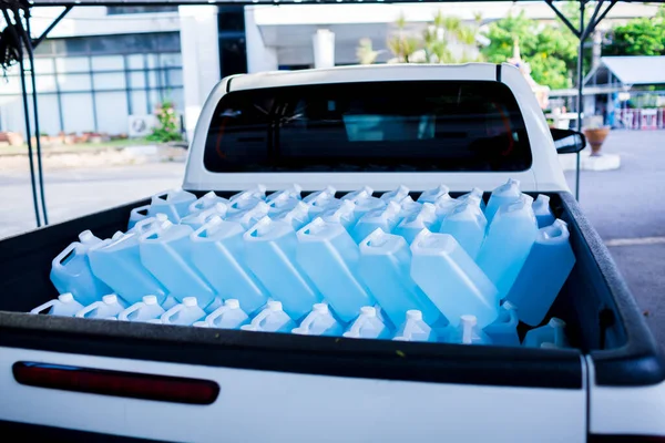 Alcohol for cleaning and sanitizing is contained in gallons on pick-up truck. Many gallon alcohol gel for sanitizing Coronavirus Covid-19. Products for sale to anti Coronavirus protection (Covid 19).