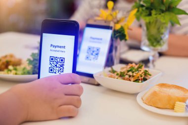 Akıllı telefonlara odaklanın. Bulanık yiyecekler, tatlı ve restorandaki müşteriler parasız dijital ödeme üretmek için QR kodunu etiketle tarayın. Qr kod ödeme kavramı.