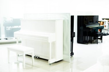 Müzikal enstrüman dükkanında siyah piyanolu beyaz piyano..
