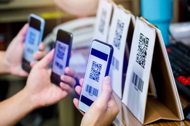 Birçok müşteri QR kodu ödemelerini ve barkodlarını taramak için akıllı telefonu tutuyor. Dijital ödeme ve online alışveriş kavramı.