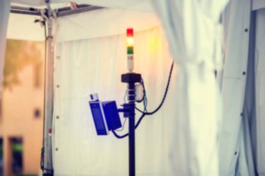 Corona virüsünün (Covid-19) yayılmasını önlemek için siren lambalı yüz termal tarayıcısının okulda veya havaalanında bulanık görüntüsü. İnsanlar vücut ısısı yüksek insanları bulmak için istasyonu tarıyorlar..