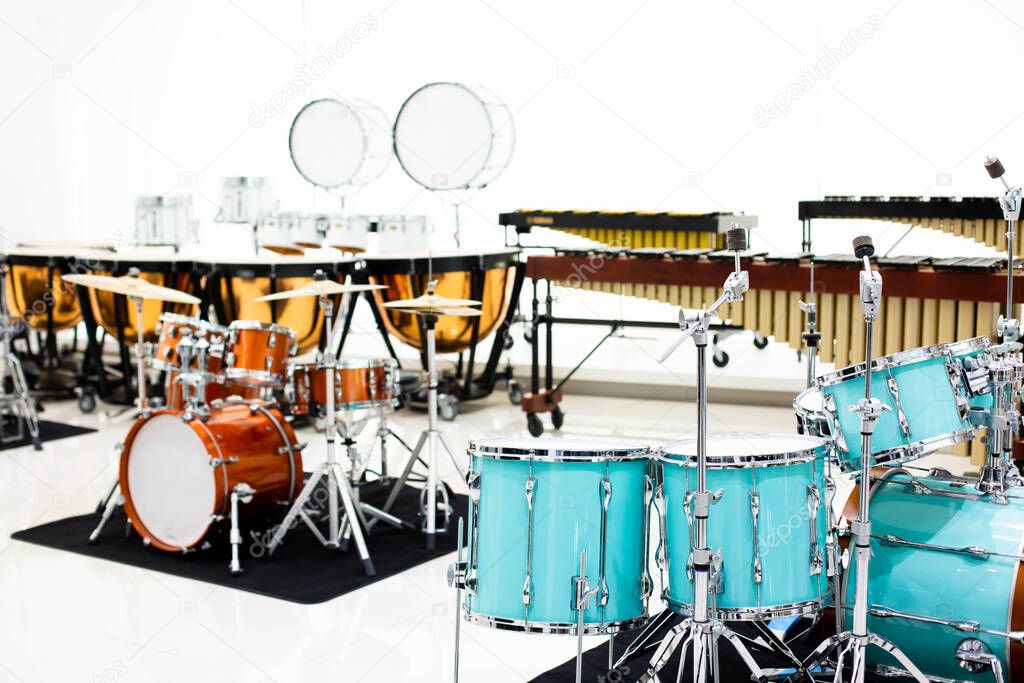 Selective focus to drum set with blurry marching band instrument in musical showroom at musical instrument store.
