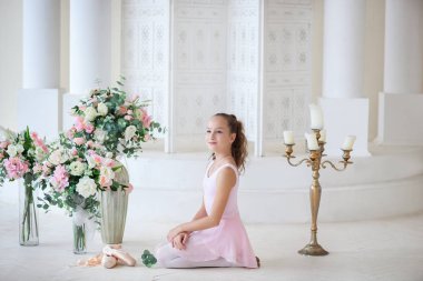 Bir bale pembe tutu ve poins sevimli bir balerin katta oturur. Dans sınıfındaki kız. Kız bale okuyor. Klasik bale, dans. Bale stüdyosu, klasik dans.