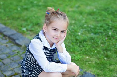 Yakından küçük kız kameraya bakıyor. Saçında renkli kalemler olan komik liseli kız. Okula dönelim. Eğitim Konsepti. Açık havada sevimli liseli kız. Okuldan sonra yorgun ve üzgün bir çocuk.