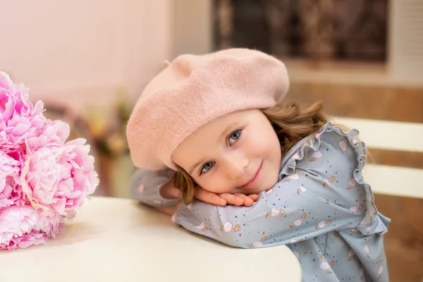 Щаслива Маленька Дівчинка Кучерявим Волоссям Сукні Береті Сидить Столом Букетом — стокове фото