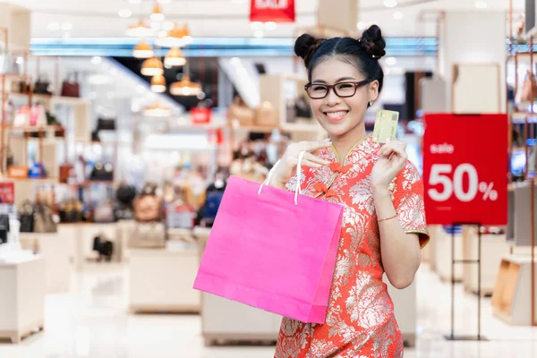 亚洲美女身穿红色旗袍 头戴信用卡提购物袋的肖像 中国的新年是中华民族和台湾人的文化 — 图库照片