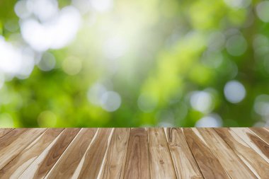 Yeşil yapraklı boş ahşap masa, metin için fotokopi alanı olan bokeh ve güneş ışığı, ürün gösterimi için şablon. yeşil doğa ve ekoloji kavramı.