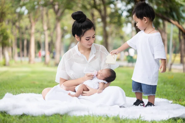 美丽的亚洲年轻妈妈或单身妈妈带着刚出生的女婴和男婴在公园里做着活动和放松 妻子和母亲抚养子女和家庭的责任概念 — 图库照片