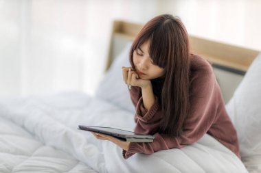 Çalışmak için tablet kullanan Asyalı kadın, eğitim, e-ticaret, yatağında sosyal medya. Corovavirus covid-19, evde kal, iş formu ev kavramı.