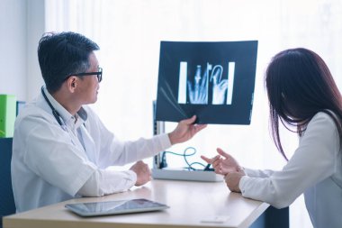 Erkek doktor kadının röntgen filmini gösterdi..