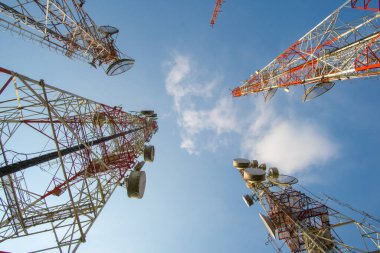 Mavi gökyüzü arkaplanlı telekomünikasyon kuleleri.