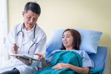 Doktorlar tabletten hasta bir kadına bir şey açıklıyorlar..