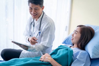 Doktorlar tabletten hasta bir kadına bir şey açıklıyorlar..