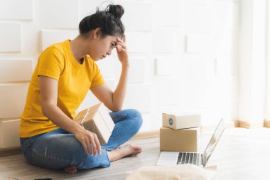 Evde çalışan Asyalı serbest kadın ve internet üzerinden küçük işletme girişimcisi KME 'yi kuruyor. Genç kadınlar çevrimiçi iş satışlarının düşmesinden endişe ediyorlar..