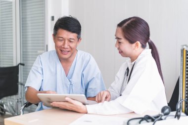 Kadın doktorlar tabletten hasta bir erkek hastaya bir şey açıklıyorlar..