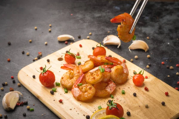 Fried shrimp with garlic and pepper on wood chopping.