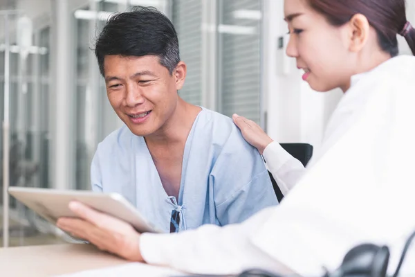 Kvinnliga Läkare Förklarar Något Från Tablett Till Sjuk Manlig Patient — Stockfoto