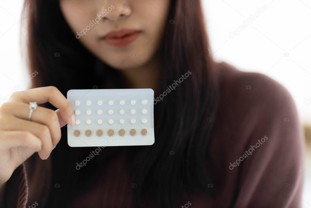 Close up birth control pill in woman's hand. concept of living in a married couple.