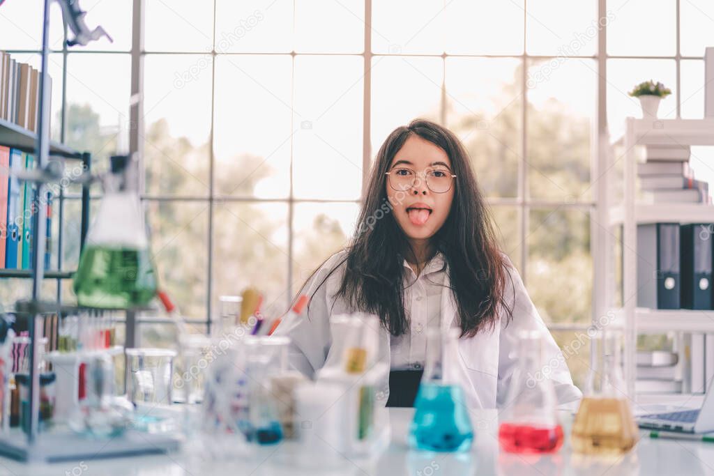 Portrait of Asian scientist is tongue showing in science room.