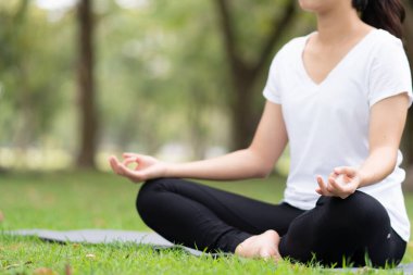 Parkta meditasyon yapan genç bayanı kapatın..