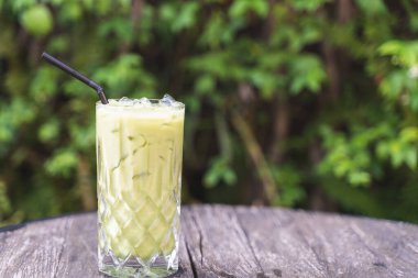 Tahta masada sütlü buzlu yeşil çay.