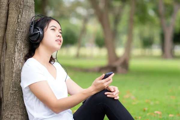 Νεαρή Γυναίκα Ακούει Μουσική Ακουστικά Στο Πάρκο — Φωτογραφία Αρχείου