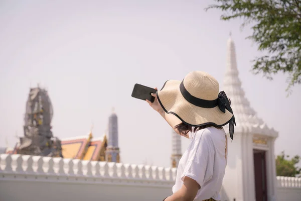 在泰国曼谷的Phra Kaew庙宇 亚洲女人头戴帽子 手持智能手机的肖像 — 图库照片