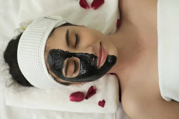 young happy woman with face masks in spa. Beauty treatments.
