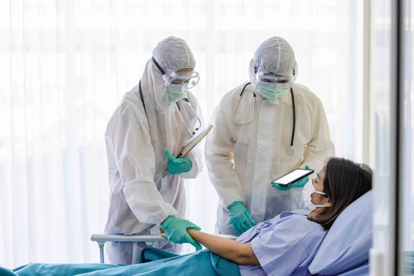 Male Female Doctors Protective Suits Masks Examining Symptoms Female Patients — Stock Photo, Image