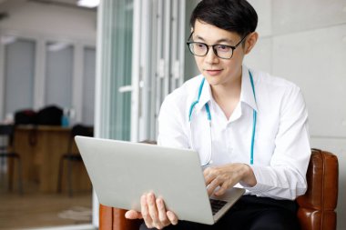 Üniformalı erkek doktorlar modern hastanede tıbbi işler için dizüstü bilgisayar kullanıyorlar. Tasarımınız için boş monitör. 