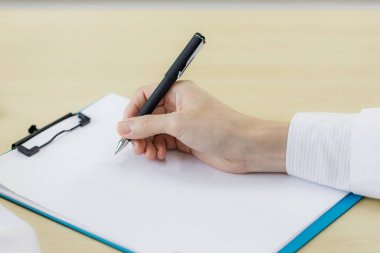 Doktorun eli boş panoya tıbbi geçmişi kaydediyor ve hastaya bir şey anlatıyor. Tıbbi ve sağlık hizmetleri kavramları