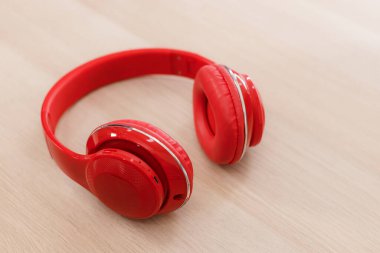 Ahşap masada kırmızı kablosuz kulaklık. hobi ve müzik konsepti.