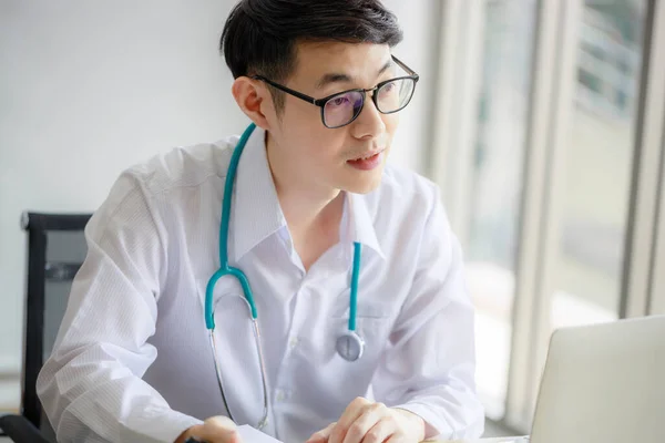 若いアジアの男性医師は クリップボードに医療史を記録し 女性患者に何かを説明しています ヘルスケアの概念 — ストック写真