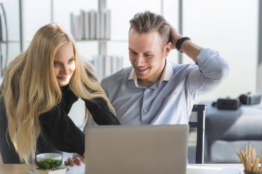 Genç iş adamı ve kadın sabah güneşiyle ev ofisinden çalışıyorlar. Sosyal ağda iletişim kuruyorlar ve çevrimiçi bilgi arıyorlar.