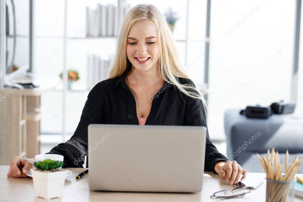 Young business woman working from home-office with morning sunshine. woman communicating in social network and searching information online.
