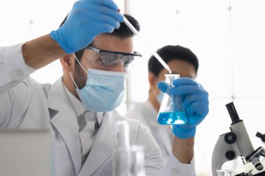 Yaşam bilimi laboratuvarında çalışan sağlık araştırmacıları. Araştırma laboratuarında çalışan erkek araştırmacı ve yönetici. Koronavirüs aşısının icadı.