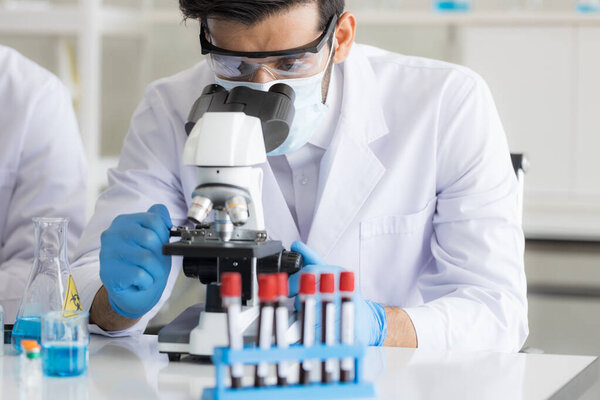 Health care researchers working in life science laboratory. Male research scientist and supervisor preparing and analyzing microscope slides in research lab. Invention of the coronavirus vaccine