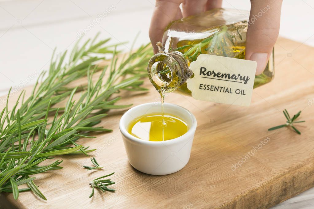 Hand pouring rosemary essential oil. Rustic style