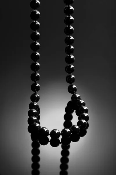 Black necklace on black background. Onyx necklace.  Jewelry concept