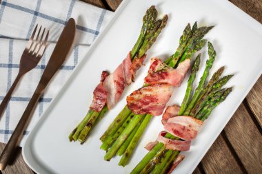 Tabakta sarılmış pastırma ile pişmiş kuşkonmaz