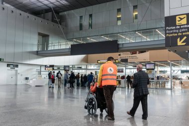 Havaalanı personeli havaalanında tekerlekli sandalyede insanları iterek iterek