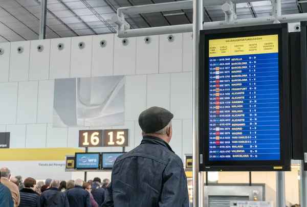 Santiago de Compostela, Hiszpania. Kwiecień 19 2019: Lotnisko Santiago de Compostela. Wnętrze terminalu pasażerskiego. Starszy mężczyzna patrząc na tablicy informacyjnej — Zdjęcie stockowe