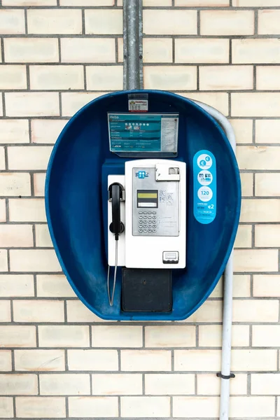 Cabina de teléfono público vintage en la pared de ladrillo. Portugal telecomunicaciones — Foto de Stock