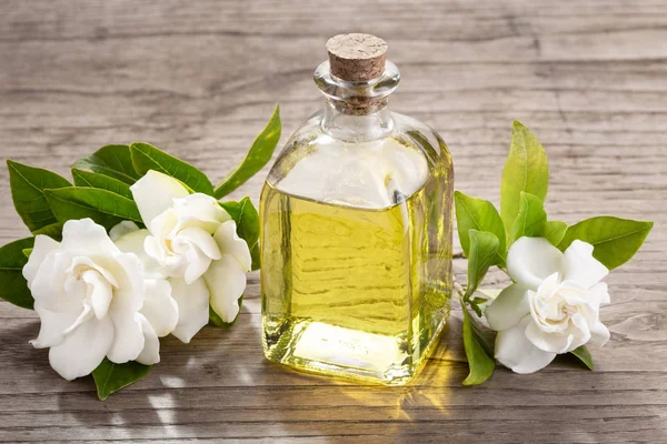 Gardenia essential oil on wooden table — Stock Photo, Image