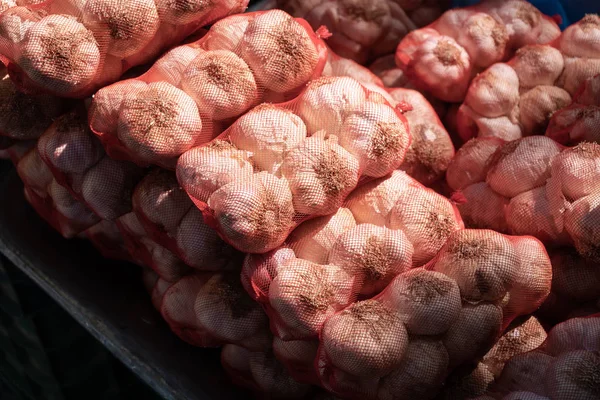 Garlics em saco de malha no mercado de agricultores — Fotografia de Stock
